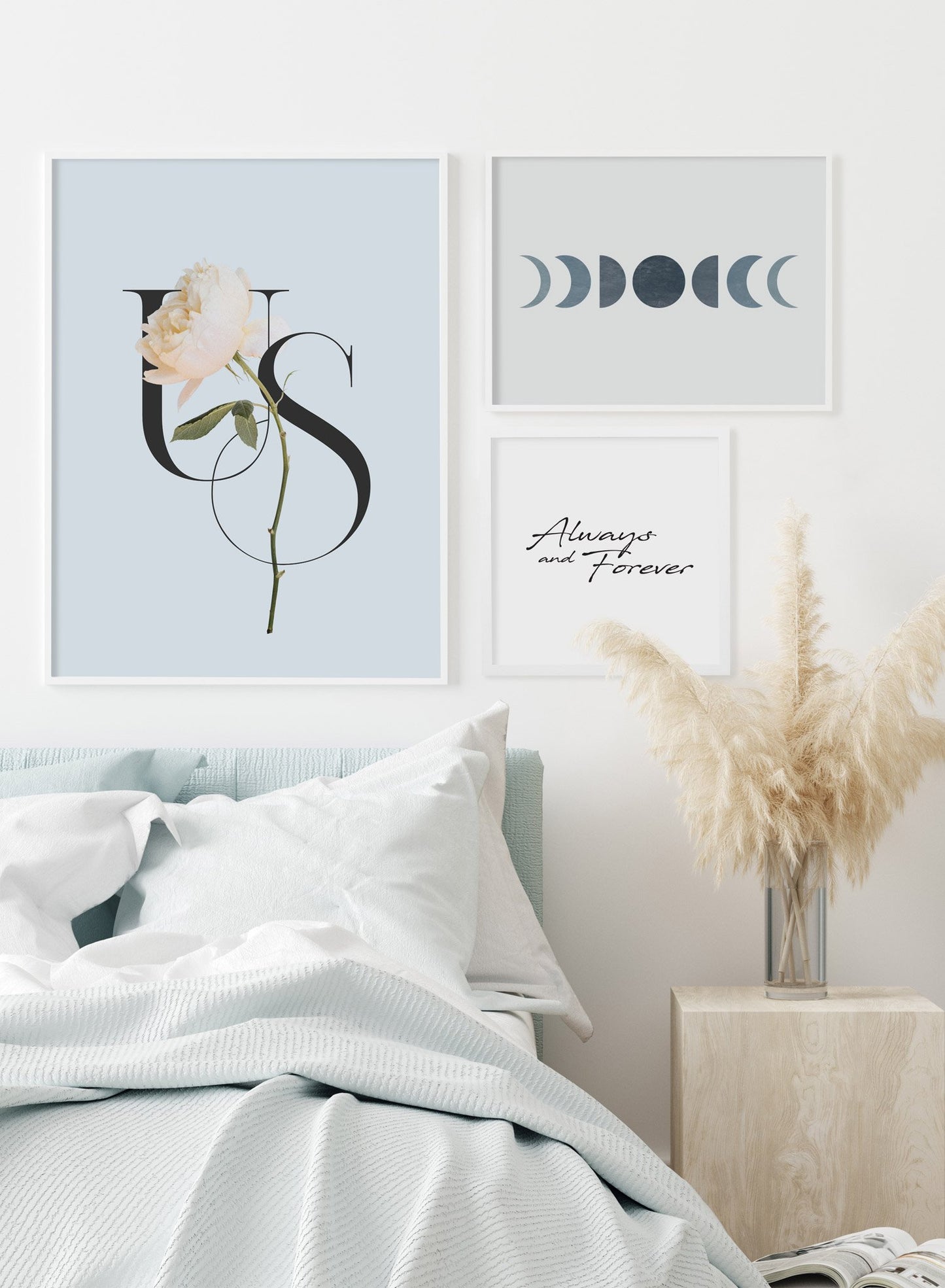 "Us" is a minimalist blue, cream and black typography poster by Opposite Wall of the word ‘us’ layered over a white flower over a baby blue background.