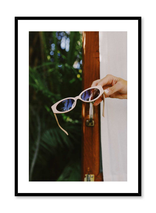 Facing the Sun is a minimalist photography poster of hand holding a pair of sunglasses by Opposite Wall.